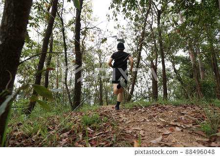Woman runner running on forest trail Woman runner running on forest trail 88496048