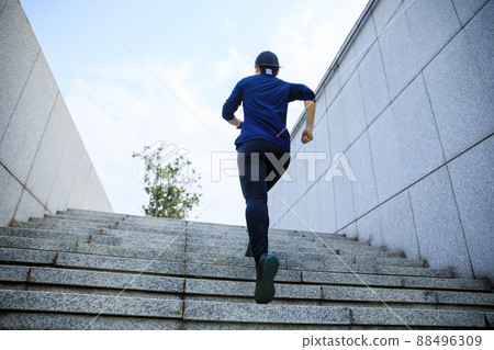 Sports woman running up stairs in city 88496309