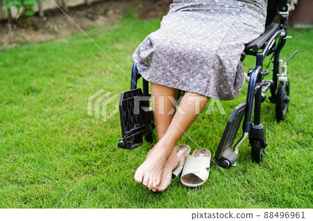Asian elderly woman disability patient sitting on wheelchair in park, medical concept. Asian elderly woman disability patient sitting on wheelchair in park, medical concept. 88496961