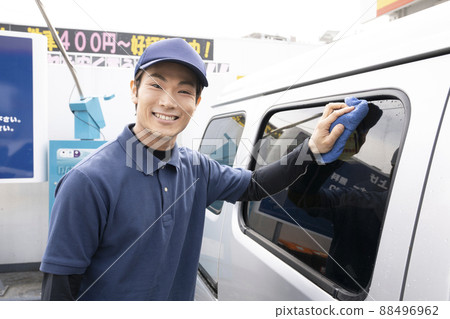 A man wiping a car that has been washed 88496962