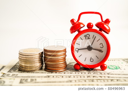 .Alarm clock with coins on US dollar banknotes, finance installment loan time. 88496963