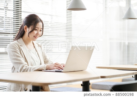 在共享辦公空間中使用筆記本電腦工作的亞洲女性 88500198
