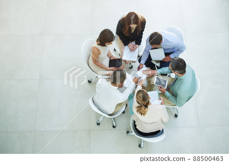 Brainstorming solutions. High angle shot of a group of businesspeople meeting in the office. 88500463