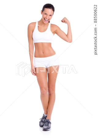 Hard as a rock. Studio shot of an attractive young woman flexing her biceps isolated on white. 88500622