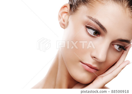 Feeling tranquil. Studio shot of a beautiful young woman touching her face isolated on white. 88500918