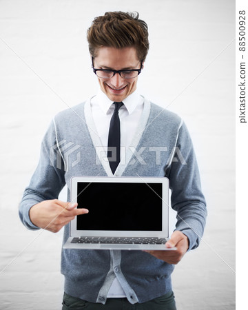 Your advertisement goes here. A young nerdy guy pointing at copyspace on his laptop screen. 88500928