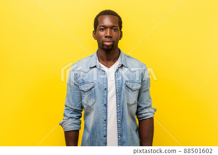 Portrait of serious self-assertive handsome man in denim casual shirt with rolled up sleeves looking smart and professional, freelancer or employee. indoor studio shot isolated on yellow background 88501602