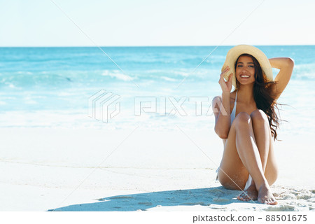 Shes ready for summer. A gorgeous young woman sitting on the beach. Shes ready for summer. A gorgeous young woman sitting on the beach. 88501675