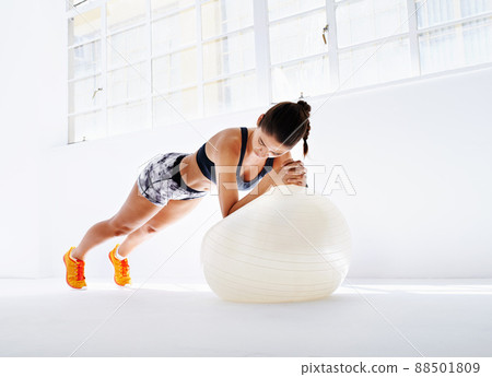Working up a sweat. Studio shot of an attractive young woman working out. Working up a sweat. Studio shot of an attractive young woman working out. 88501809
