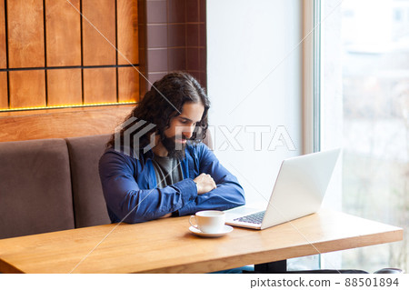 Portrait of tired handsome young adult man freelancer in casual style sitting in cafe with laptop, sleeping after hard overtime work, closed eyes bussinessman in office. Indoor, lifestyle concept Portrait of tired handsome young adult man freelancer in casual style sitting in cafe with laptop, sleeping after hard overtime work, closed eyes bussinessman in office. Indoor, lifestyle concept 88501894