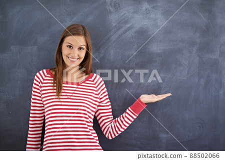 May I direct your attention right here. Portrait of a gorgeous young woman standing in front of a blackboard. May I direct your attention right here. Portrait of a gorgeous young woman standing in front of a blackboard. 88502066