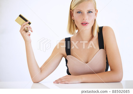 Shes a big spender. Gorgeous young woman sitting and holding a credit card - portrait. 88502085