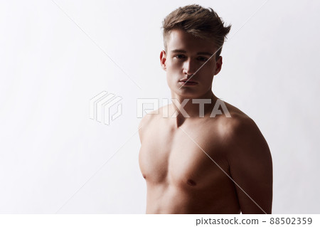 Sensuality of a man. Head and shoulders studio shot of young man with bare shoulders. 88502359