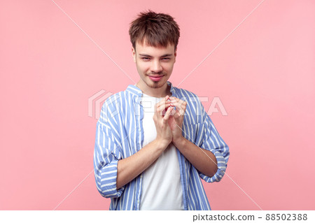 Portrait of funny tricky brown-haired man with small beard and mustache in casual striped shirt thinking devious plan with cunning face expression. indoor studio shot isolated on pink background 88502388