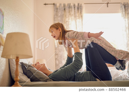 Imagination is her favourite toy. Shot of a mother and her little girl playing together in the bedroom. 88502466
