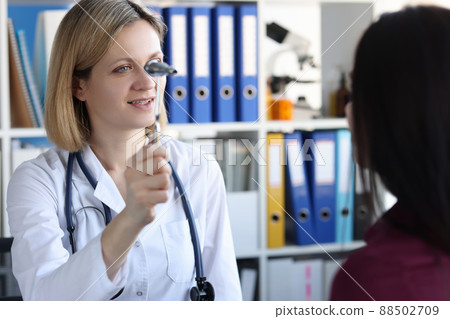 Neurologist holds hammer in front of patient eyes in clinic 88502709
