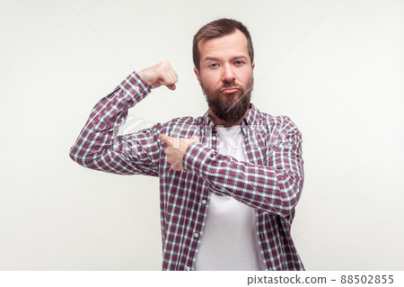 I am strong. Portrait of proud bearded man in casual plaid shirt pointing at raised hand demonstrating biceps, confident in body feeling powerful. indoor studio shot isolated on white background 88502855