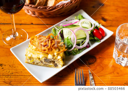 Quiche Lorraine slice with fried onions and vegetable salad Quiche Lorraine slice with fried onions and vegetable salad 88503466