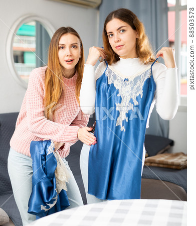 Two young women choosing clothes to wear 88503578