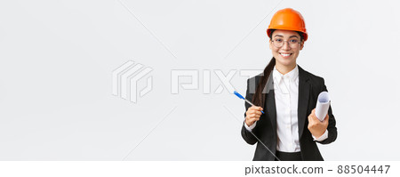 Smiling successful female entrepreneur, chief construction engineer in helmet and suit, holding blueprints and pen, signing contract with building supplier, white background Smiling successful female entrepreneur, chief construction engineer in helmet and suit, holding blueprints and pen, signing contract with building supplier, white background 88504447