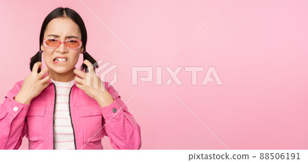 Image of angry, pissed off korean adult female model, shaking fists and shouting, screaming outraged, standing over pink background Image of angry, pissed off korean adult female model, shaking fists and shouting, screaming outraged, standing over pink background 88506191