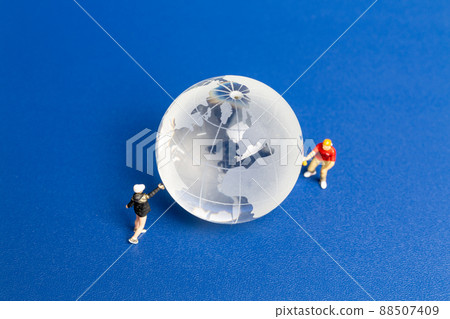 Miniature people Teenager spraying paint crytal globe on blue background Miniature people Teenager spraying paint crytal globe on blue background 88507409