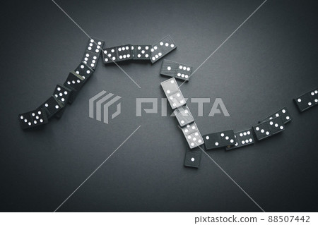 Black dominoes chain on dark table background Black dominoes chain on dark table background 88507442