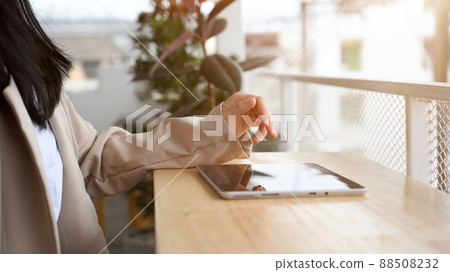 Female or businesswoman remote working in the coffee shop, using portable tablet Female or businesswoman remote working in the coffee shop, using portable tablet 88508232