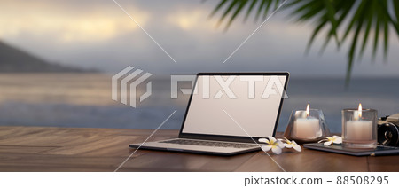 Laptop, aroma candles on wood table against blurred sea view. Travel and remote working Laptop, aroma candles on wood table against blurred sea view. Travel and remote working 88508295
