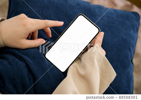 Close-up image, Female using a smartphone in her living room. Close-up image, Female using a smartphone in her living room. 88508301