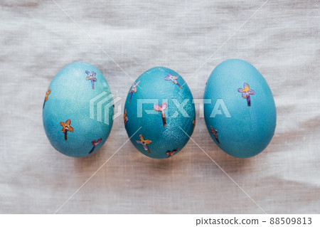 Pressed flower Easter eggs on beige tablecloth. 88509813