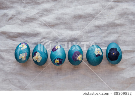 Pressed flower Easter eggs on beige tablecloth. Pressed flower Easter eggs on beige tablecloth. 88509852