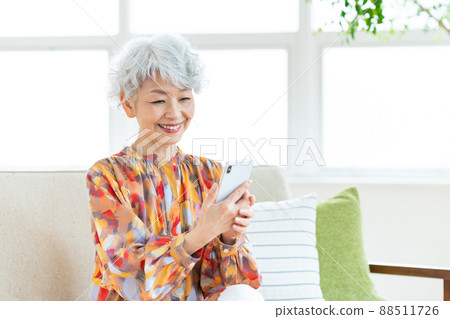 看智能手機的資深婦女 看智能手機的資深婦女 88511726