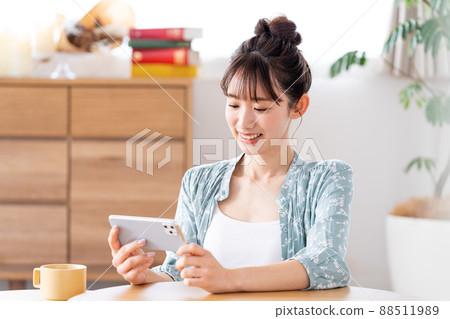 A young woman watching a video on her smartphone 88511989