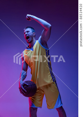 One excited man, basketball player shouting isolated on purple background in neon light. Goals, sport, motion, activity concepts. 88514410