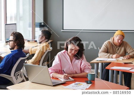 Group of young multi-ethnic self-employed people sitting at tables and working with devices abd papers in coworking space Group of young multi-ethnic self-employed people sitting at tables and working with devices abd papers in coworking space 88516930