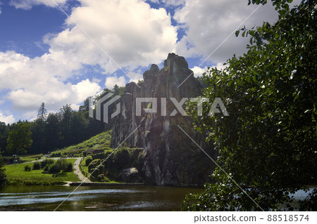 Externsteine near Detmold, Germany with pond in front and cloudy sky, mystic sandstone rocks in Teutoburg Forest Externsteine near Detmold, Germany with pond in front and cloudy sky, mystic sandstone rocks in Teutoburg Forest 88518574