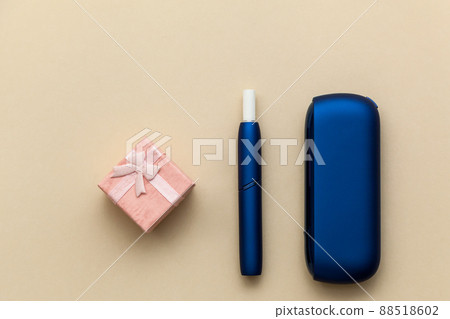 Iqos electronic blue cigarette on a beige background. Iqos electronic blue cigarette on a beige background. 88518602