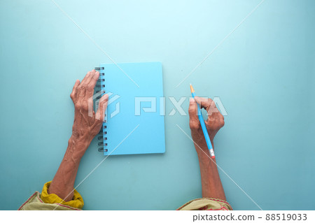 top view of senior women hand writing on notepad. 88519033