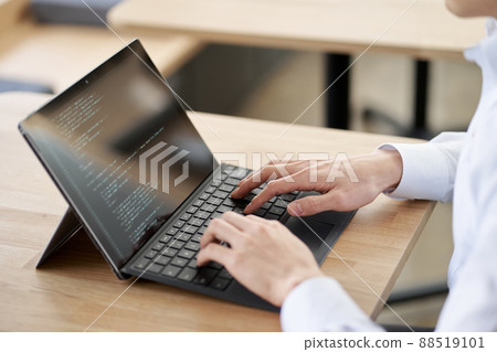 Asian programmer writing code on a laptop Asian programmer writing code on a laptop 88519101