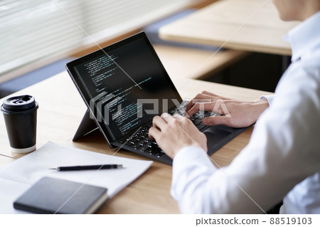 Asian programmer writing code on a laptop Asian programmer writing code on a laptop 88519103