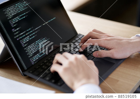 Asian programmer writing code on a laptop Asian programmer writing code on a laptop 88519105