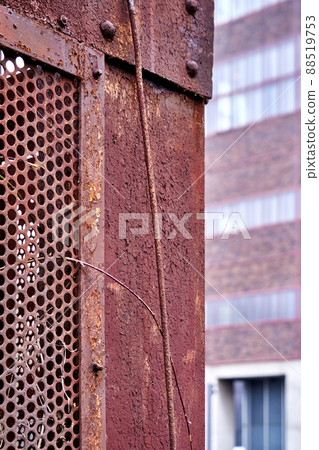 Rusty iron box in front of blurred building, abstract background image 88519753