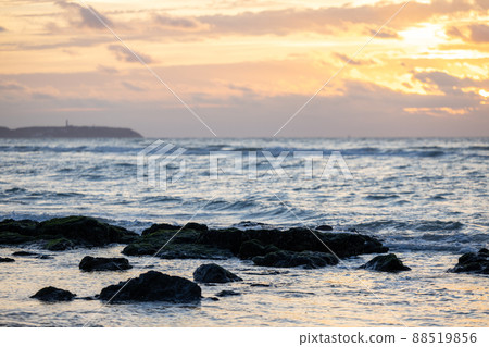 Sunset on a rocky stone beach. Orange sunset on the beach with big stones. Large stones with a 88519856