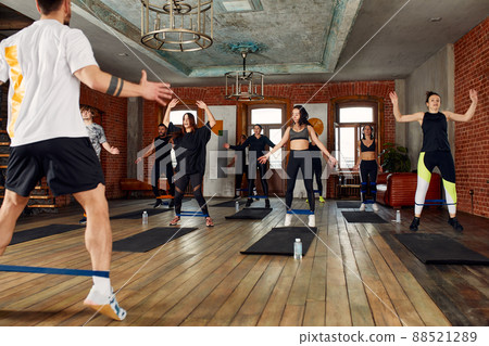 fitness, sport, training, gym and lifestyle concept - group of people working out with rubber bands in the gym. 88521289