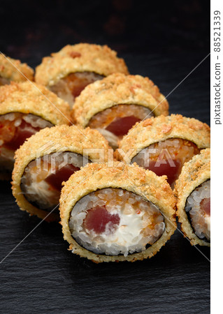 Hot fried sushi roll with salmon. Sushi menu. Japanese food. Hot fried sushi roll on black background 88521339