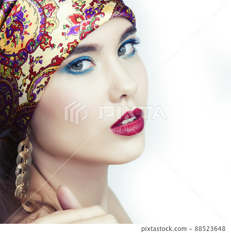 young pretty modern girl with bright shawl on head emotional posing isolated on white background, asian people ethnicity 88523648