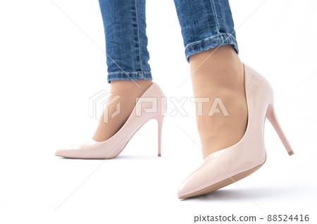 Slender female legs in patent leather shoes with high heels. Dark blue jeans. Fashion and Style. Side view 88524416
