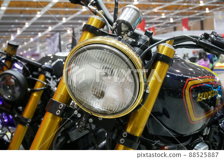 SELANGOR, MALAYSIA - 8 APRIL 2022: Branded motorcycle classic headlights installed on custom motorcycles. The motorcycle was displayed to the public in a large showroom. 88525887