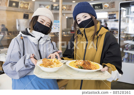 Snowboarder woman carrying food at a food court with anti-infection control at ski resorts Snowboarder woman carrying food at a food court with anti-infection control at ski resorts 88528161